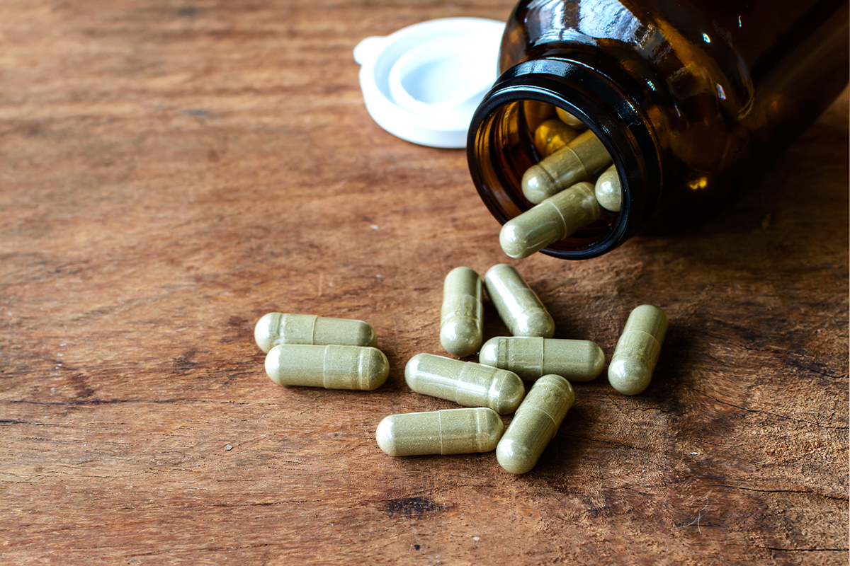 closeup shot of green capsules on wooden table